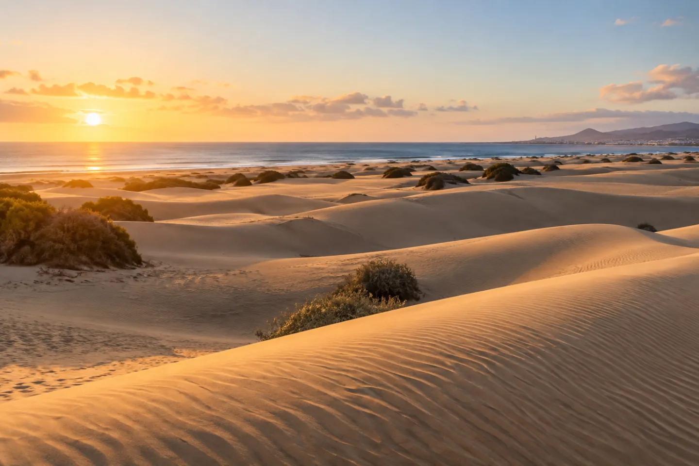 Maspalomas dunes meeting the Atlantic in warm morning light.