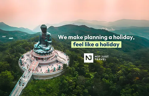 large budha statue in Hong Kong with the text 'we make planning a holiday, feel like a holiday. Not Just Travel'